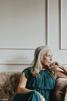 an older woman sitting on top of a couch