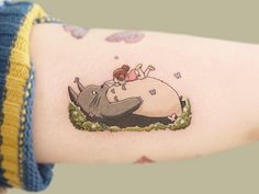 a woman's arm with a rhinoceros tattoo on it and an elephant laying down