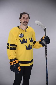 a man in a hockey jersey holding a hockey stick