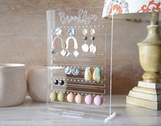 a clear acrylic display with earrings on it and a lamp in the background