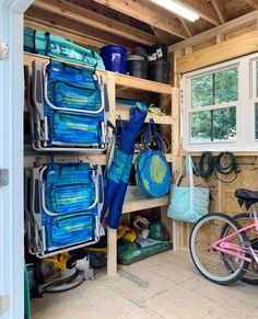 a bicycle is parked in front of a storage area with blue bags and other items