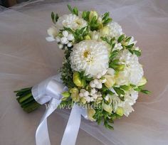 a bridal bouquet with white flowers and greenery