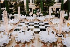 a large checkered floor with tables and chairs set up for a formal function in front of a building