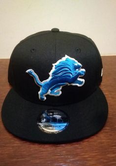 New Era Detroit Lions Black 9FIFTY Mens Snapback Hat - 59005841 Sports Fan Snapback Hat With Team Logo, Adjustable Snapback Hat With Team Logo, Adjustable Flat Bill Baseball Cap With Team Logo, Fan Gear Snapback Hat With Team Logo, Snapback Hat With Team Logo For Fan Gear, Fan Merchandise Snapback Hat With Team Logo, Adjustable Snapback Cap With Team Logo, Adjustable Flat Bill Fitted Hat For Sports Fans, Adjustable Flat Bill Sports Fan Hat