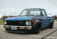 a blue pick up truck parked in a parking lot