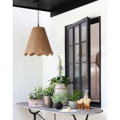 a table topped with potted plants next to a window