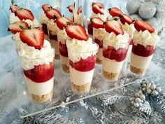 desserts with strawberries and whipped cream are arranged on a clear platter, ready to be served