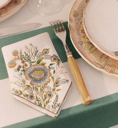 a place setting with plates, silverware and napkins