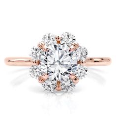 an engagement ring with two tone gold and white diamonds on the center, surrounded by round brilliant