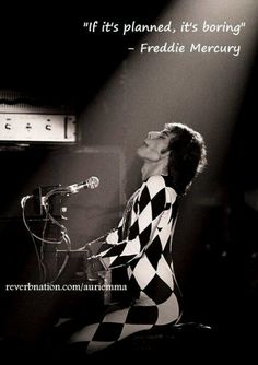 a woman in checkered dress sitting at a microphone and singing into a mic on stage