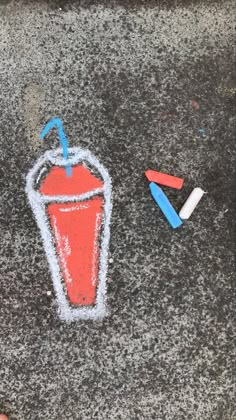 chalk drawing of a drink and two crayons on the ground