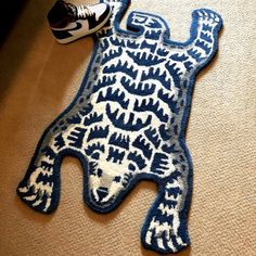 a blue and white bear rug on the floor next to a pair of black sneakers