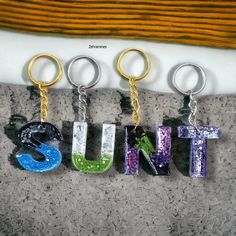 three different key chains that spell out the word unit