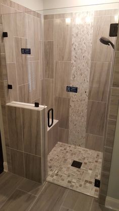 a walk in shower sitting inside of a bathroom next to a tiled wall and floor