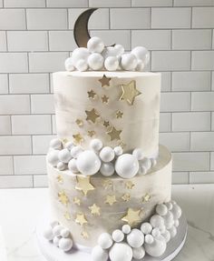 a white cake with gold stars and moon decorations