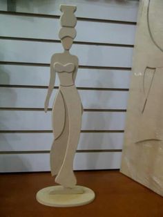 a paper sculpture of a woman standing next to a wall