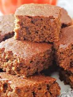 several pieces of brownies stacked on top of each other in front of an orange pumpkin