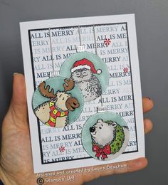 a hand holding up a christmas card with an image of two bears and a reindeer