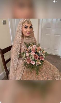 a woman sitting in a chair holding a bouquet of flowers and wearing a wedding dress