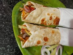 two tortillas on a green plate with onions