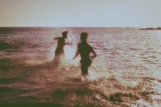 two people running in the water near each other