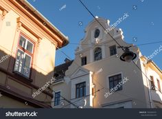 an old building with many windows and some wires in front of it, on a sunny day