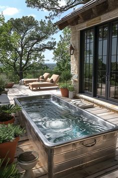 a hot tub sitting on top of a wooden deck next to a patio with lots of potted plants