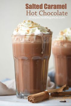 salted caramel hot chocolate is garnished with whipped cream and cinnamon sticks