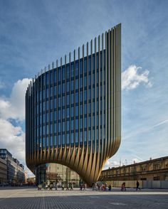 a large building with many windows on the side and people walking in front of it