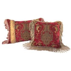 two red and gold decorative pillows with tassels