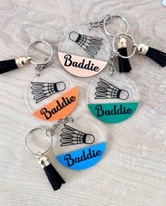 four personalized keychains with tassels that say paddle, baddie, and balline