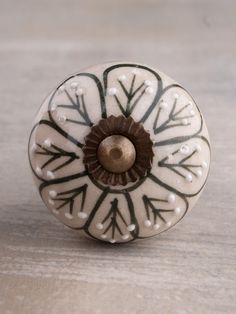 a white and brown decorative knob on a wooden surface