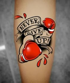 a tattoo with boxing gloves on it that says never give up