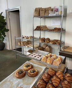 several trays of baked goods on display in a room with carpeted flooring