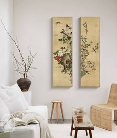 two paintings hanging on the wall in a living room