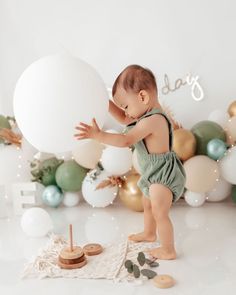 a baby is playing with a large balloon