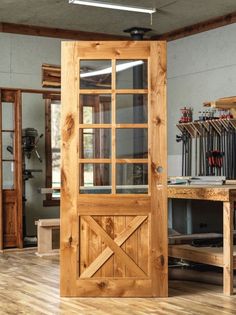 an open wooden door in a room with hard wood flooring and storage racks on the wall