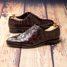 a pair of brown shoes sitting on top of a wooden floor