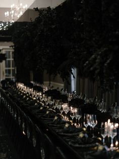 a long table is set with candles and plates for formal dinner guests to sit at