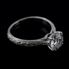 an antique style diamond engagement ring on a black background