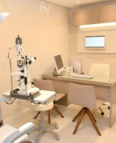 an eye exam room with two chairs and a laptop