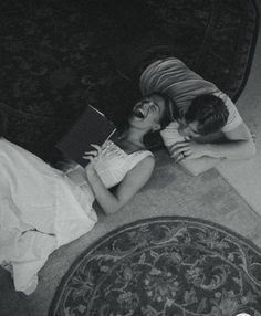 two women are laying on the floor reading books