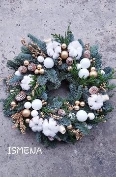 a christmas wreath with white and gold ornaments