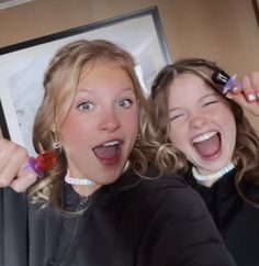 two young women are brushing their hair together