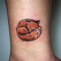 a small tattoo of a sleeping fox on the side of a woman's leg