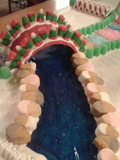 a cake decorated with marshmallows, candy and icing in the shape of a bridge