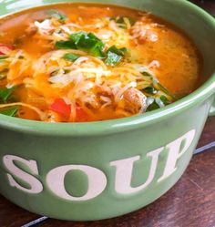 a bowl of savory sausage soup with peppers and spinach on the side