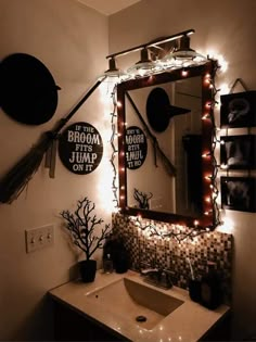 a bathroom decorated with halloween decorations, lights and decor on the wall above the sink