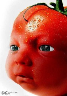 a close up of a small child's face with a tomato on its head