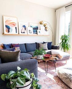 a living room filled with lots of furniture and plants on top of the couches